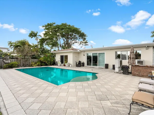 a view of a house with swimming pool and sitting area