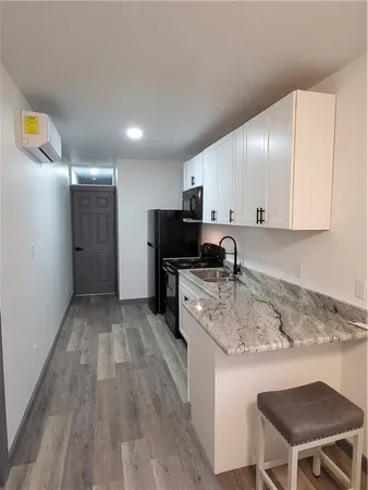 a kitchen with a sink cabinets and wooden floor