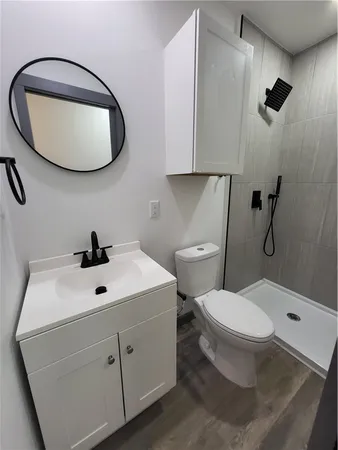 a bathroom with a toilet a sink and mirror