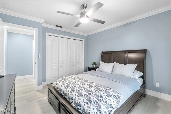 a bedroom with a large bed and a chandelier