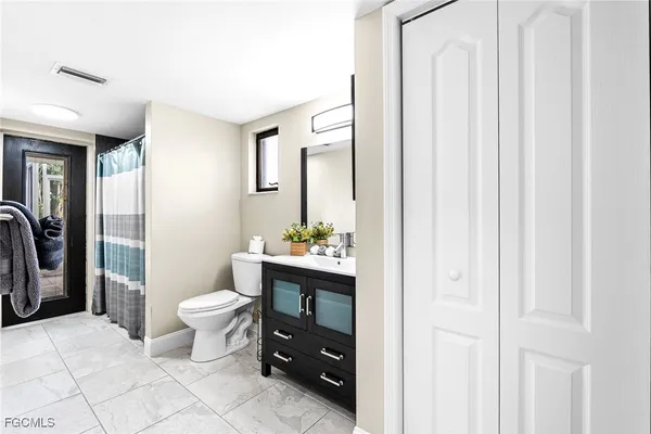 a bathroom with a toilet a sink and a mirror