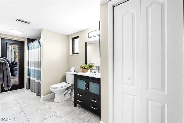 a bathroom with a toilet a sink and a mirror