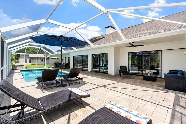 a view of a patio with table and chairs under an umbrella