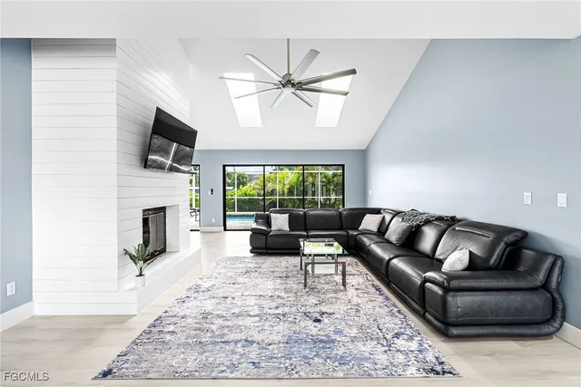 a living room with furniture a fireplace and a flat screen tv