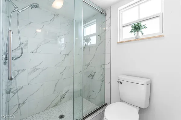 a bathroom with a toilet and a shower