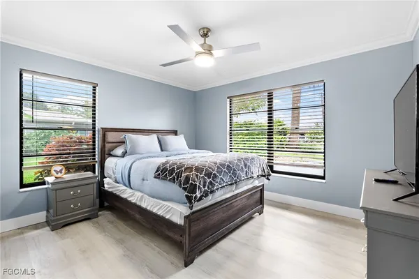 a bedroom with a bed next to a window with a flat screen tv