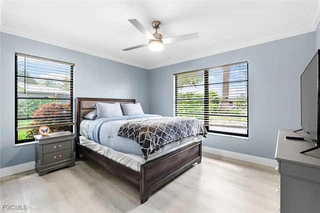 a bedroom with a bed next to a window with a flat screen tv