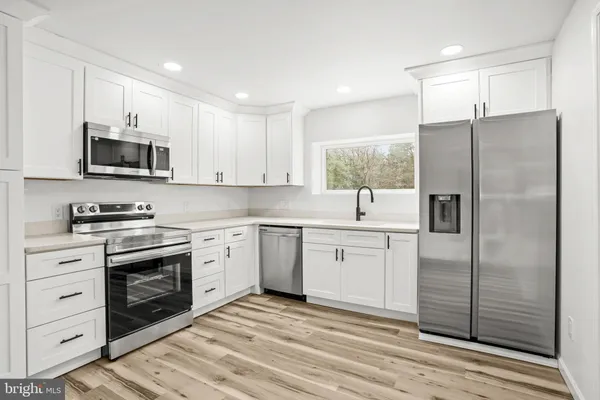 a kitchen with cabinets stainless steel appliances and a window