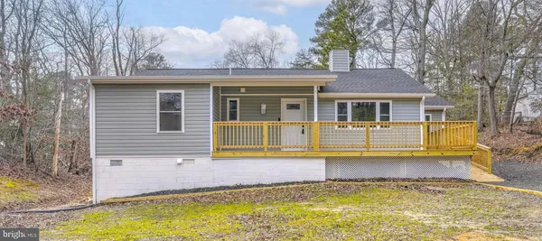 a view of a house with pool and chairs