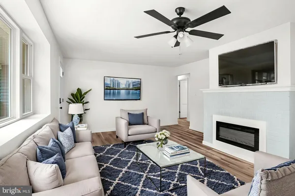 a living room with furniture a flat screen tv and a fireplace