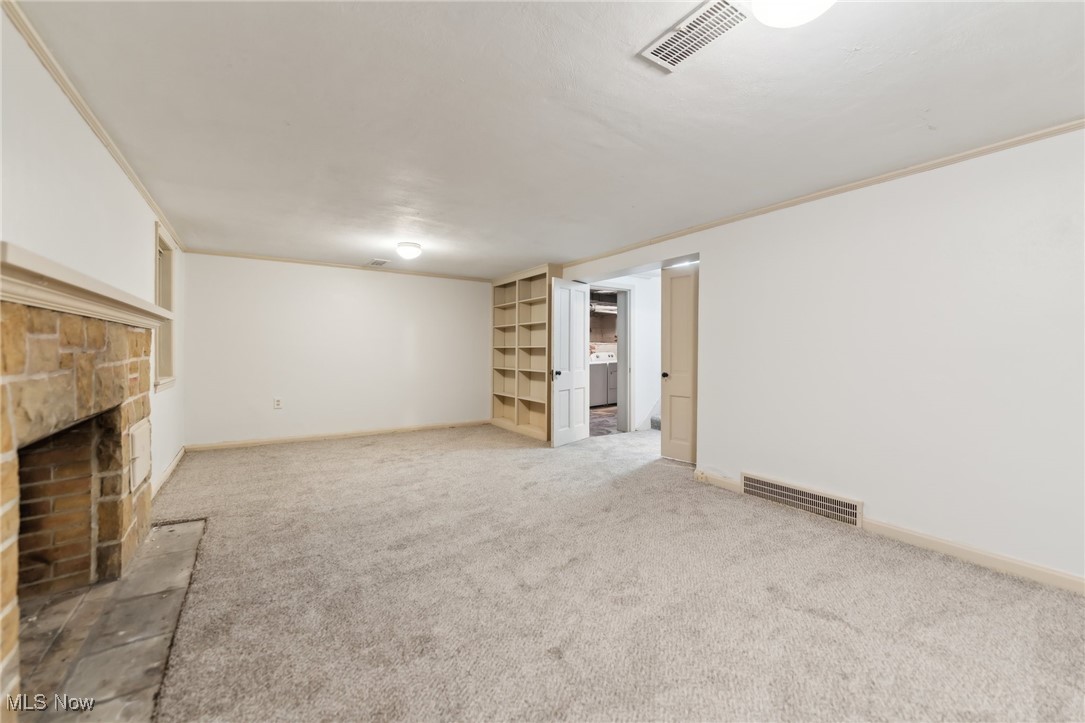 1542 Kew Road Cleveland, OH 44118 - Photo 14 of 23 Unfurnished living room with washer / dryer, crown molding, carpet, and a fireplace
