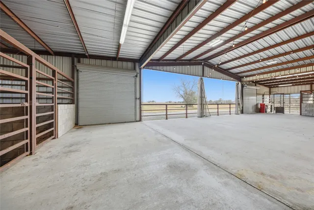 a view of a lake with lawn chairs and large trees