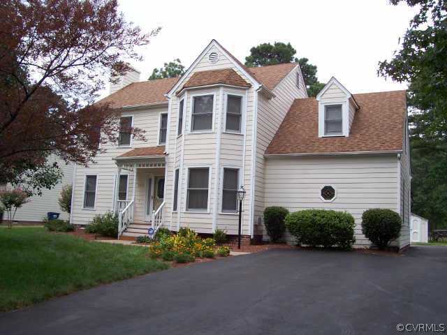 a front view of a house with a garden and plants