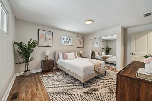 a bedroom with a large bed and a potted plant