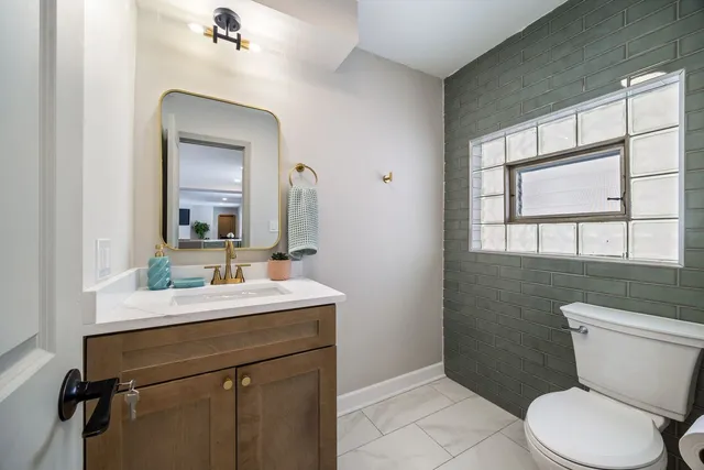 a bathroom with a toilet sink and mirror