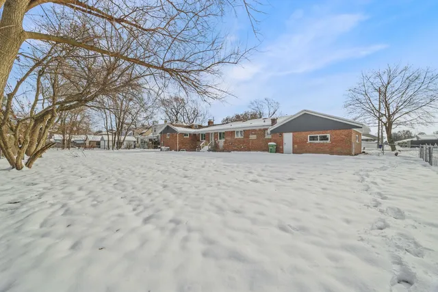 a view of large house with a snow in front of yard