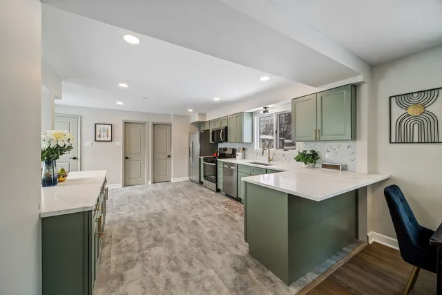 a kitchen with kitchen island a sink stove and refrigerator
