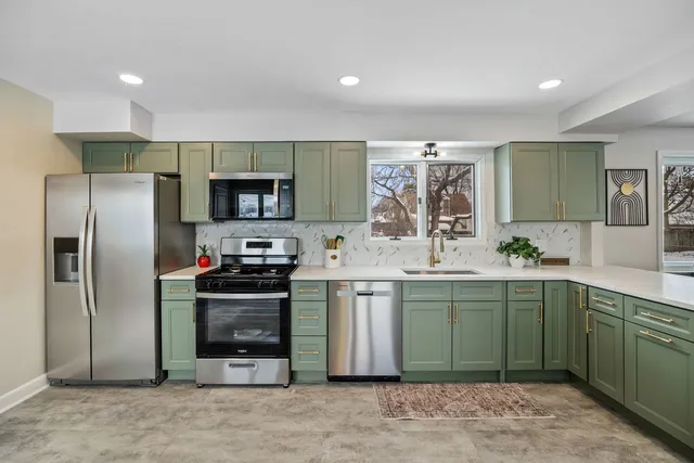 a kitchen with stainless steel appliances granite countertop a refrigerator and a sink