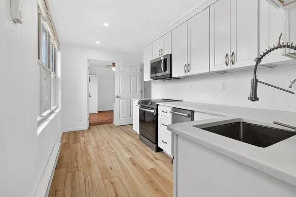 a kitchen with granite countertop white cabinets and white appliances