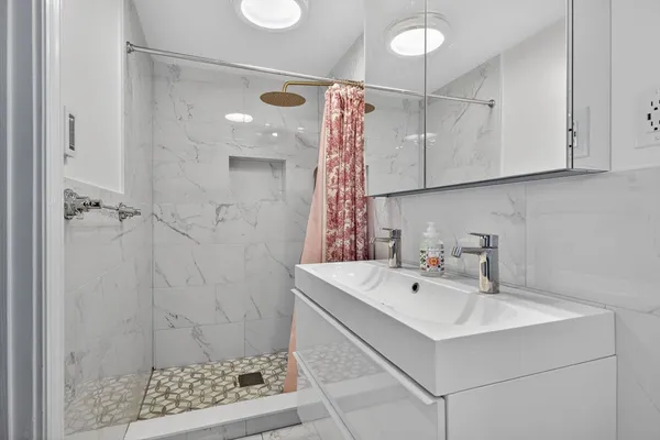 a bathroom with a sink a mirror and shower