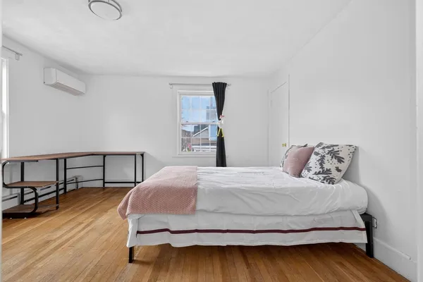 a bedroom with a bed and wooden floor