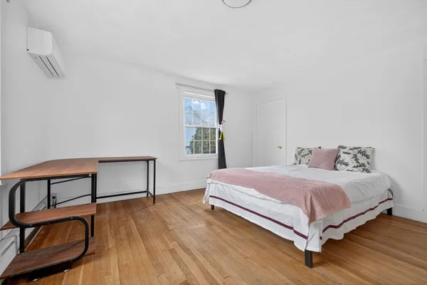 a bedroom with a bed chair and a window