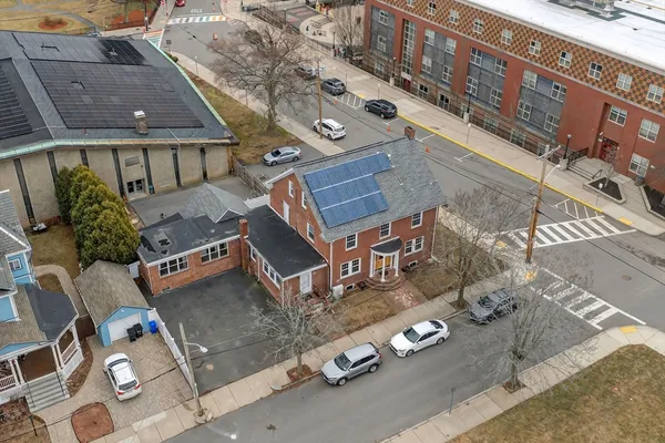 an aerial view of a house with parking