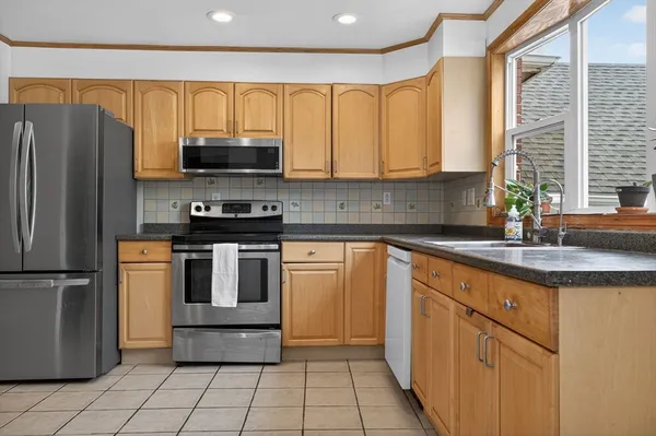 a kitchen with kitchen island granite countertop a sink stainless steel appliances and cabinets