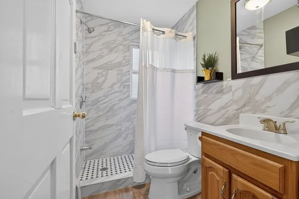 a bathroom with a sink a toilet and shower