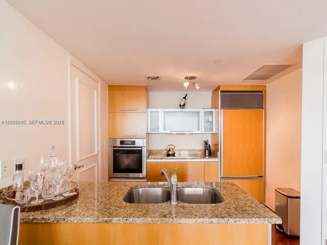a view of a kitchen with a sink and a refrigerator
