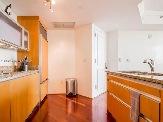 a kitchen with granite countertop a sink cabinets and stainless steel appliances