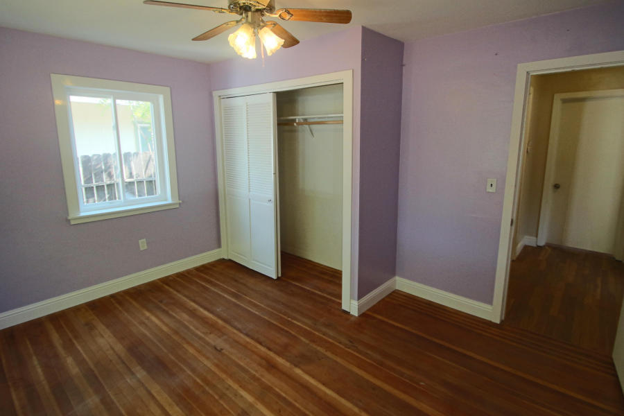 4569 Cedars Road Redding, CA 96001 - Photo 12 of 22 an empty room with wooden floor and a ceiling fan