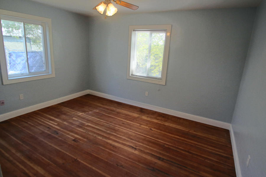 4569 Cedars Road Redding, CA 96001 - Photo 14 of 22 an empty room with wooden floor and windows