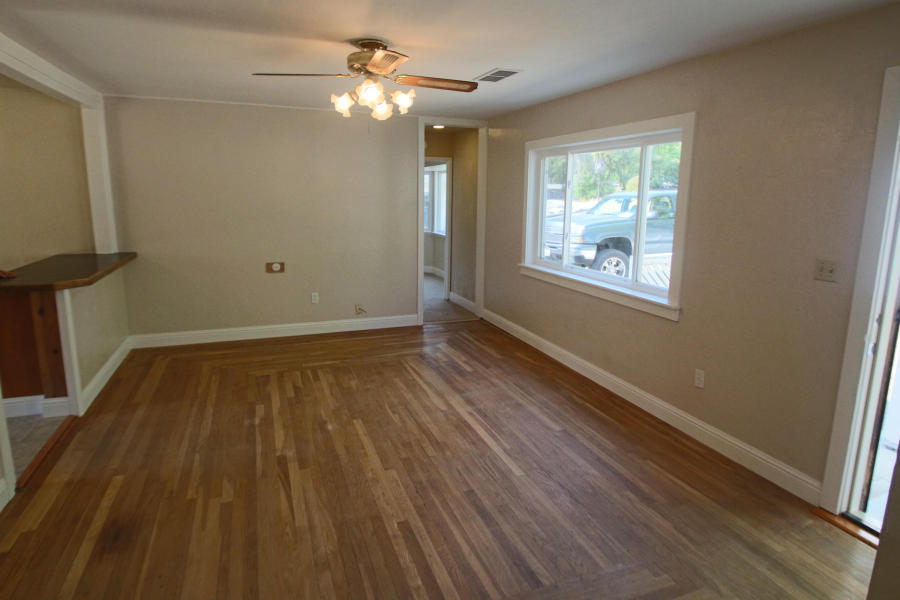 4569 Cedars Road Redding, CA 96001 - Photo 2 of 22 a view of an empty room with wooden floor and a window