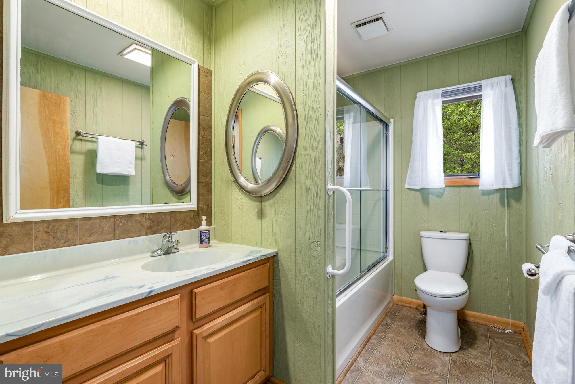 296 Mountainside Road Berkeley Springs, WV 25411 - Photo 20 of 27 a bathroom with a toilet sink and mirror