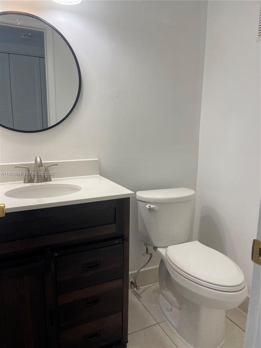 119 Tilford F, Unit 119 Deerfield Beach, FL 33442 - Photo 21 of 36 a bathroom with a toilet a sink and mirror