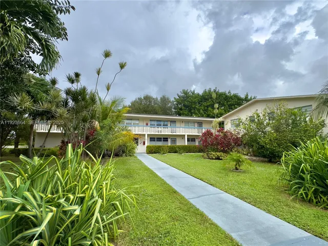 a view of a garden with a house in the background