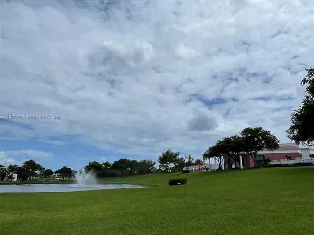 a view of a green field with sitting in the background