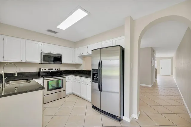 a kitchen with stainless steel appliances granite countertop a refrigerator and a stove top oven