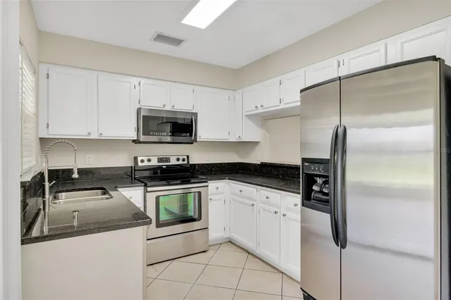 a kitchen with stainless steel appliances granite countertop a stove a refrigerator and a microwave
