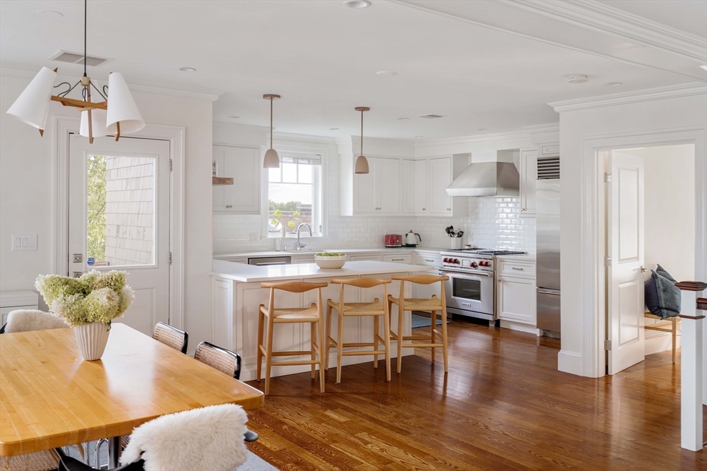 27 Summit Avenue, Unit 2 Brookline, MA 02446 - Photo 13 of 34 a kitchen with stainless steel appliances kitchen island granite countertop a table and chairs in it