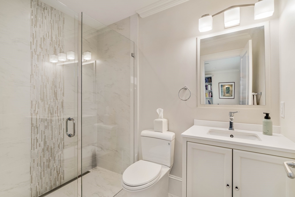 27 Summit Avenue, Unit 2 Brookline, MA 02446 - Photo 29 of 34 a bathroom with a toilet a sink a mirror and vanity