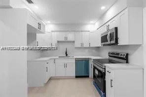 a kitchen with stainless steel appliances granite countertop a sink and cabinets