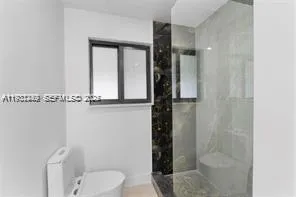 a bathroom with a toilet and a shower
