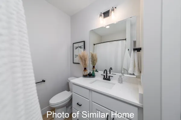 a bathroom with a sink toilet and mirror