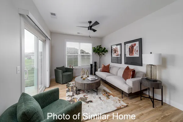 a living room with furniture potted plant and a large window