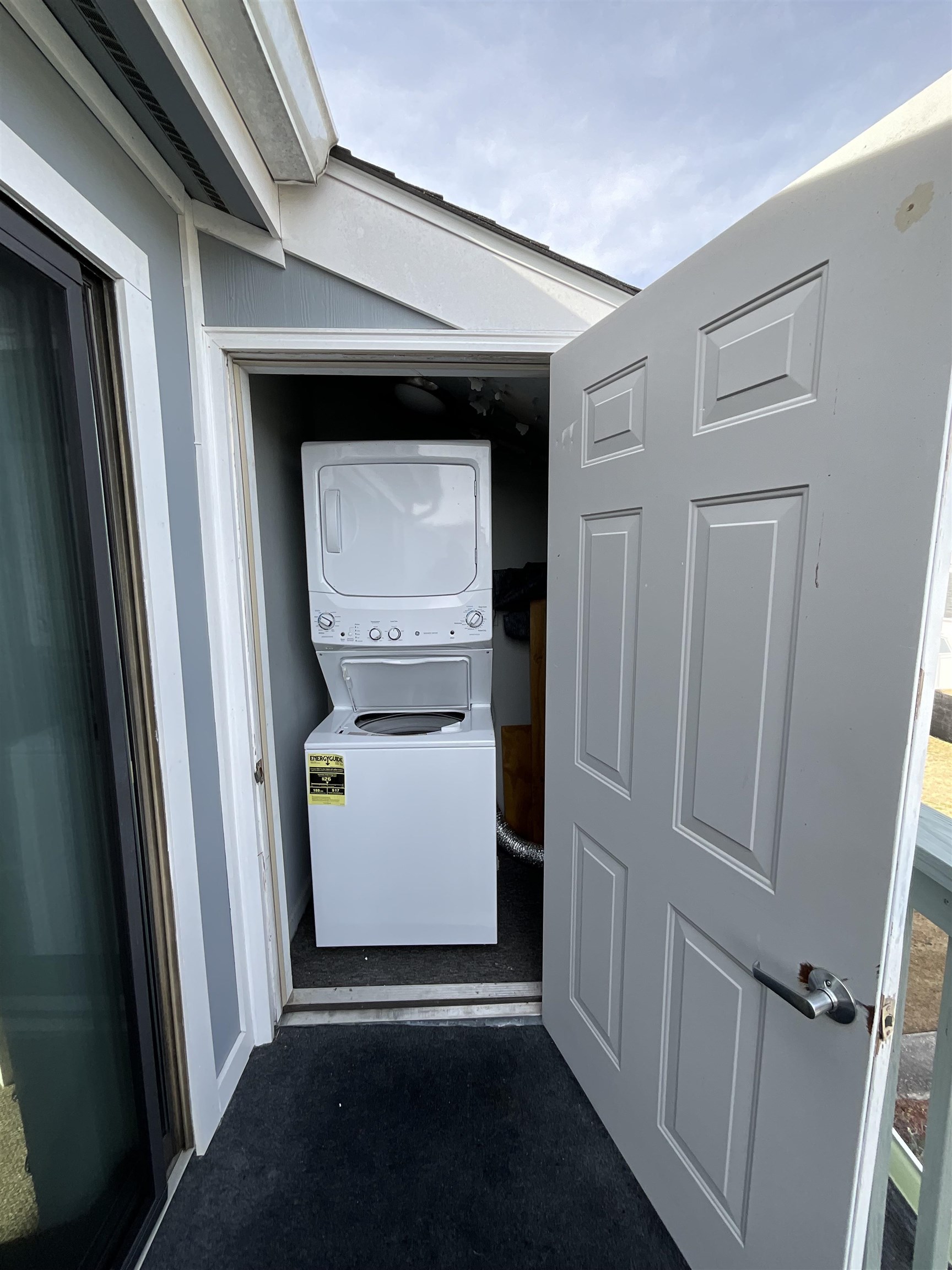 1880 Colony Drive, Unit 11O Surfside Beach, SC 29575 - Photo 13 of 14 Laundry area with stacked washing machine and dryer and dark colored carpet