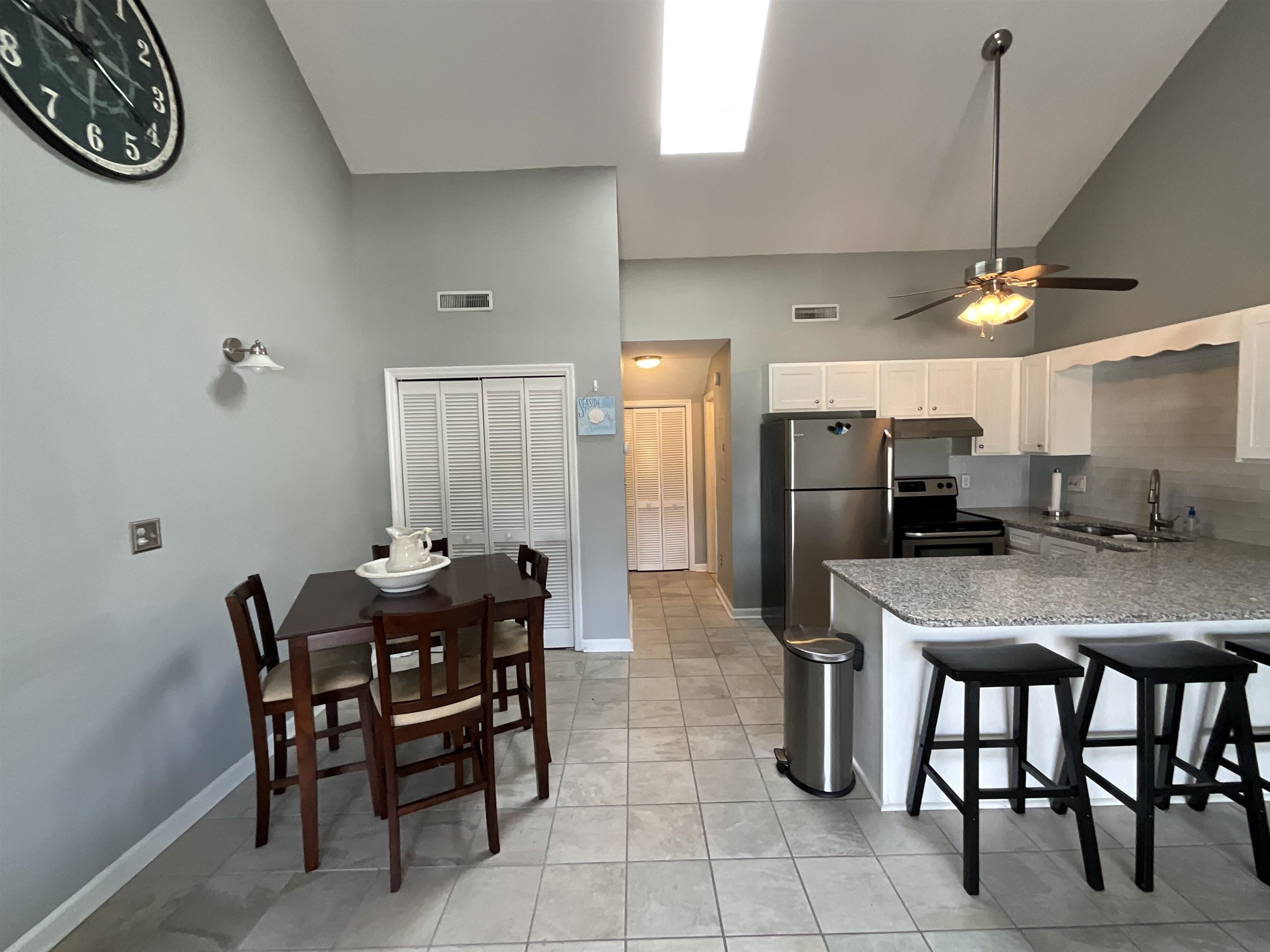 1880 Colony Drive, Unit 11O Surfside Beach, SC 29575 - Photo 7 of 17 Kitchen with high vaulted ceiling, stainless steel appliances, a kitchen breakfast bar, white cabinets, and a peninsula
