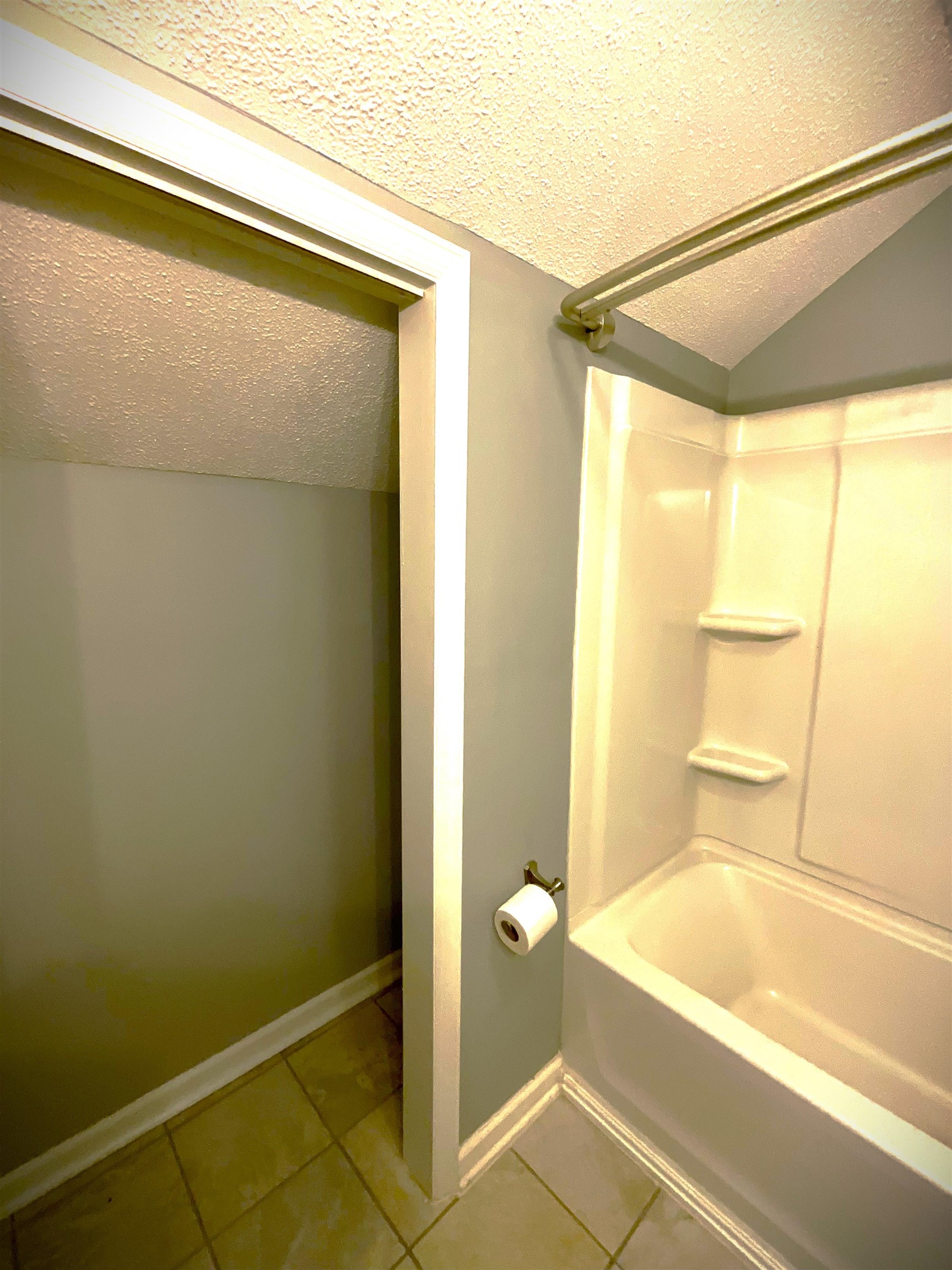 1880 Colony Drive, Unit 11O Surfside Beach, SC 29575 - Photo 7 of 14 Full bath with a textured ceiling, light tile patterned floors, vaulted ceiling, and bathing tub / shower combination