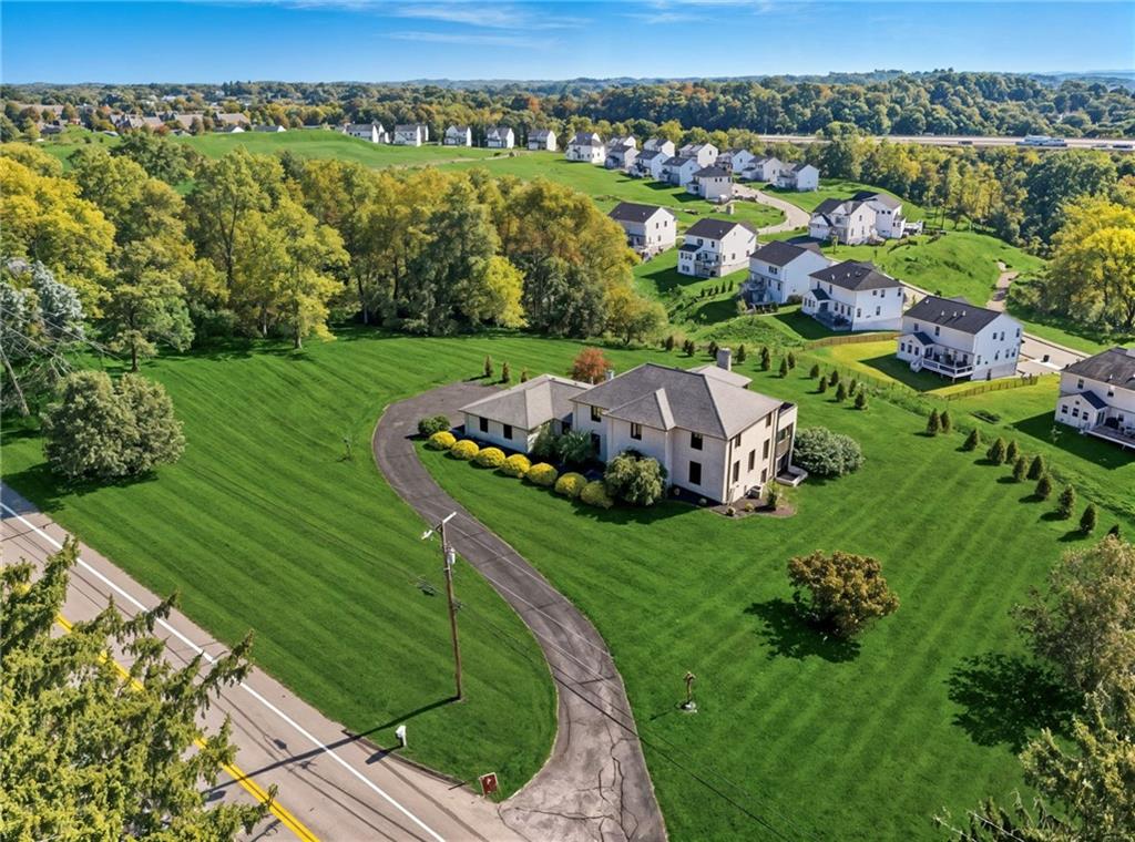 an aerial view of a house with yard green space and mountain view in back